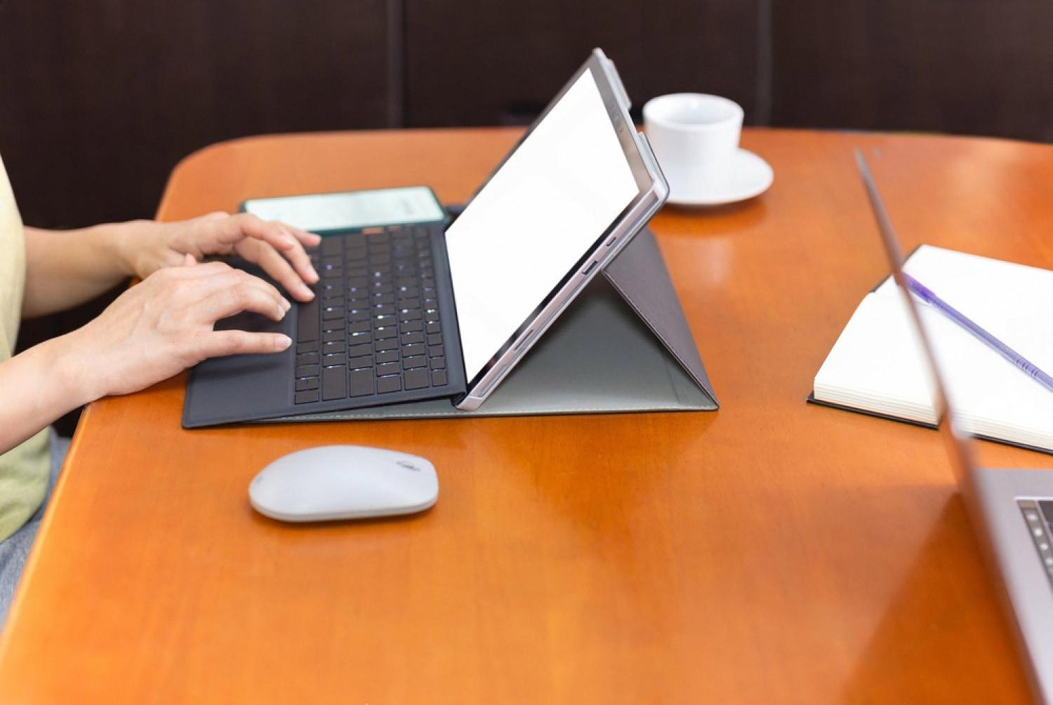 Person working on a tablet at a desk, illustrating outsourced IT services for UAE businesses
